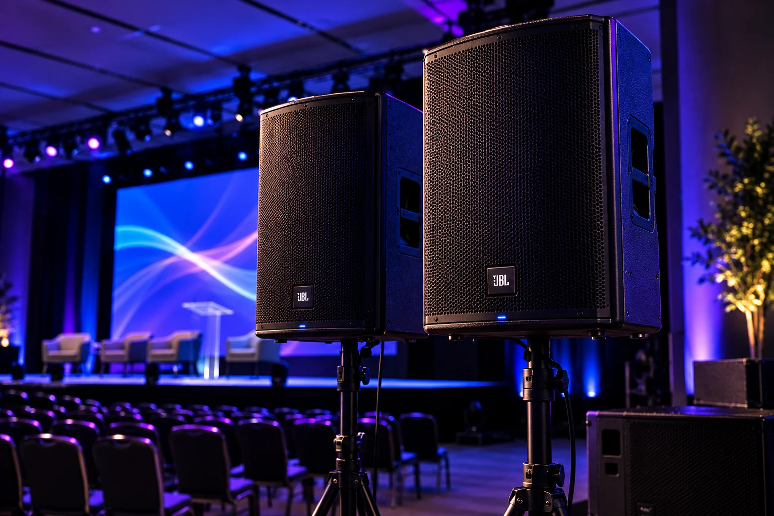 Caixas de som ativas de 12 e 15 polegadas em tripé, com subwoofer, em salão de evento
